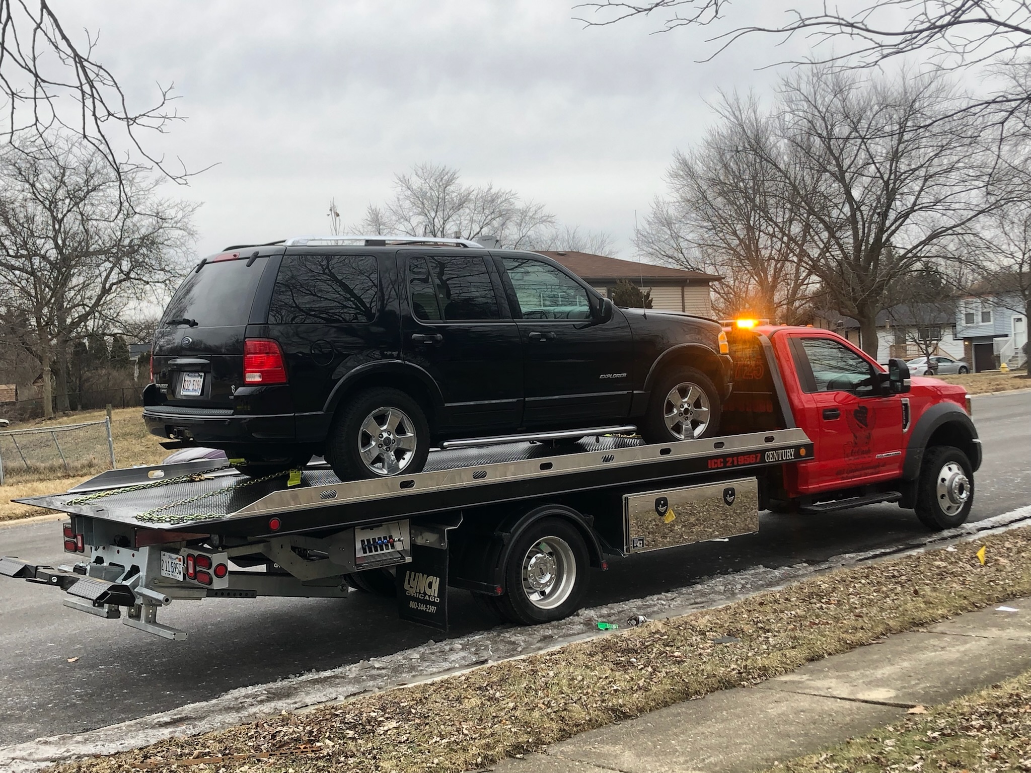 red-truck-towing-with-a-car-on-the-back-of-it.