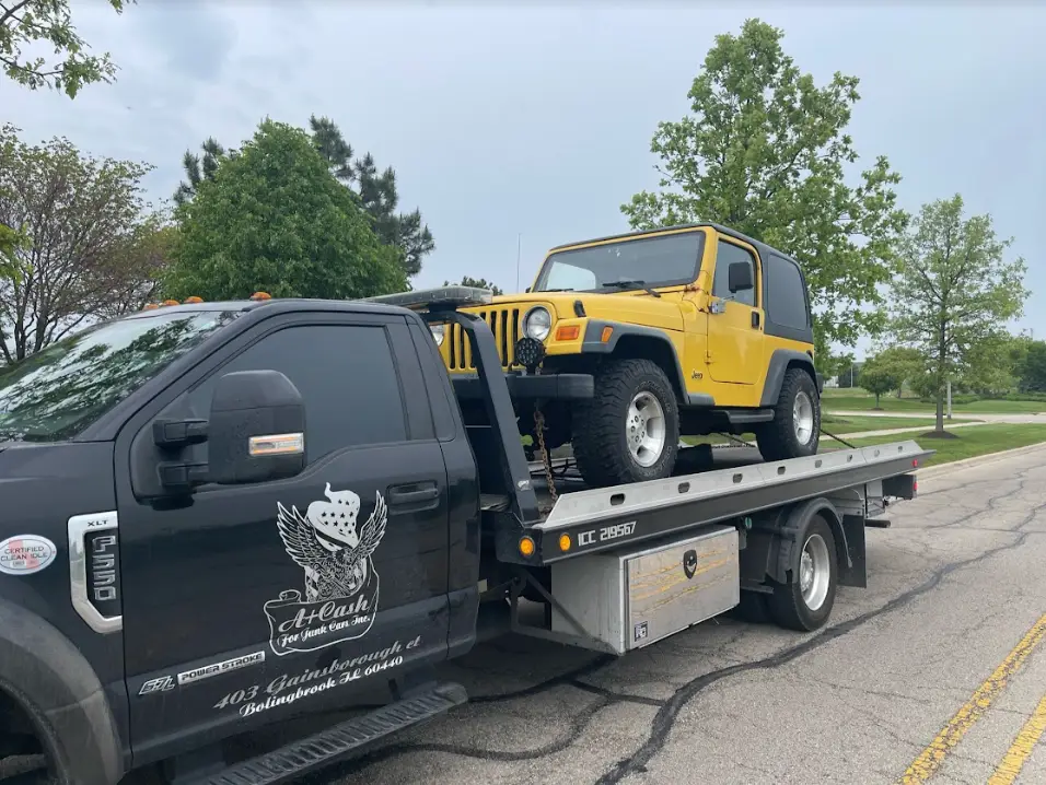 A+ Cash For Junk Cars truck towing a yellow jeep on the flatbed in the residential street