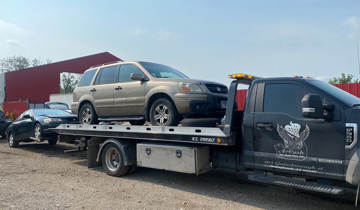 junk car being carried by a company truck that tows away junk cars and sell for cash payment
