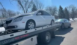 a small junk car getting towed by truck