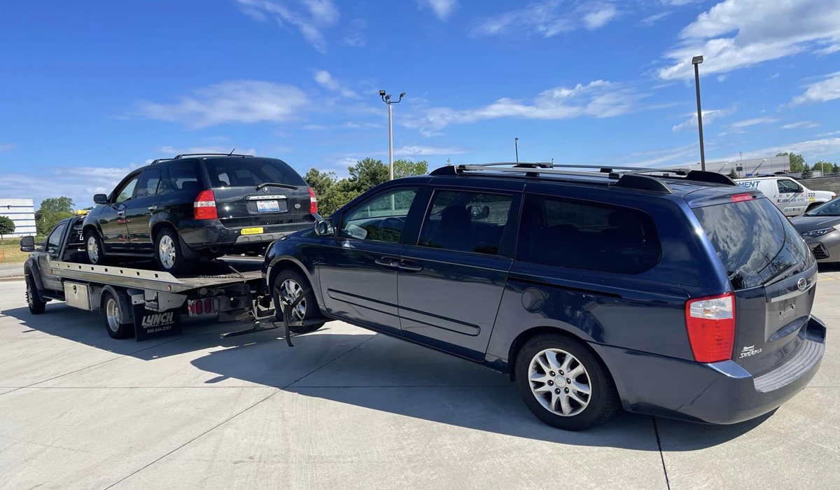 two junk vehicles getting towed away