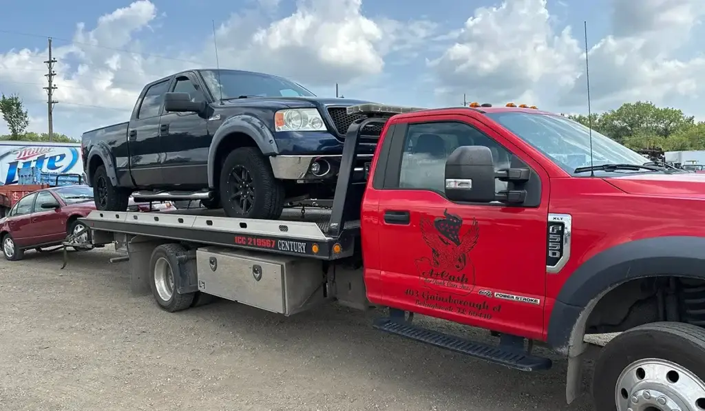 Red tow truck hauling a junk car, representing a reliable service for selling your junk car efficiently.