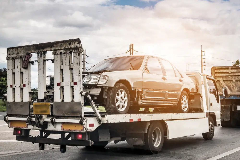 A damaged car being towed by a professional junk car removal service
