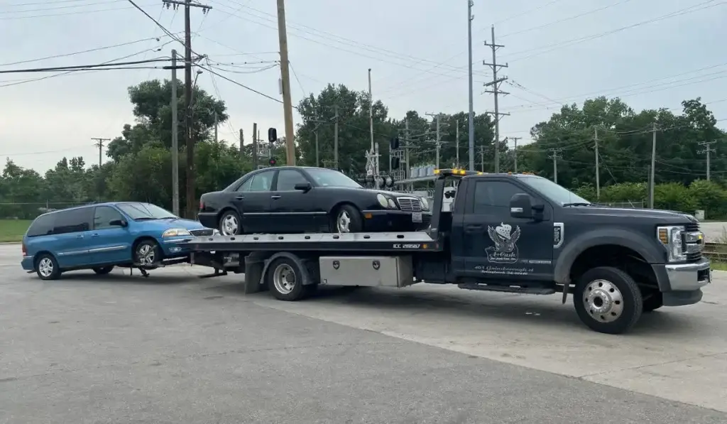 Tow truck transporting two vehicles, showcasing efficient and reliable junk car removal services in action.