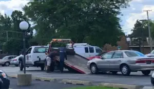 Tow truck loading a vehicle, highlighting the process of selling junk cars for cash and recycling.