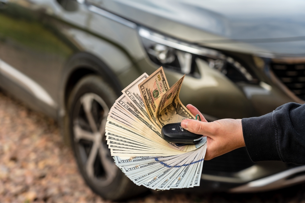 A man receiving money after disposing a car to a professional junk car removal service in Lemont, IL.