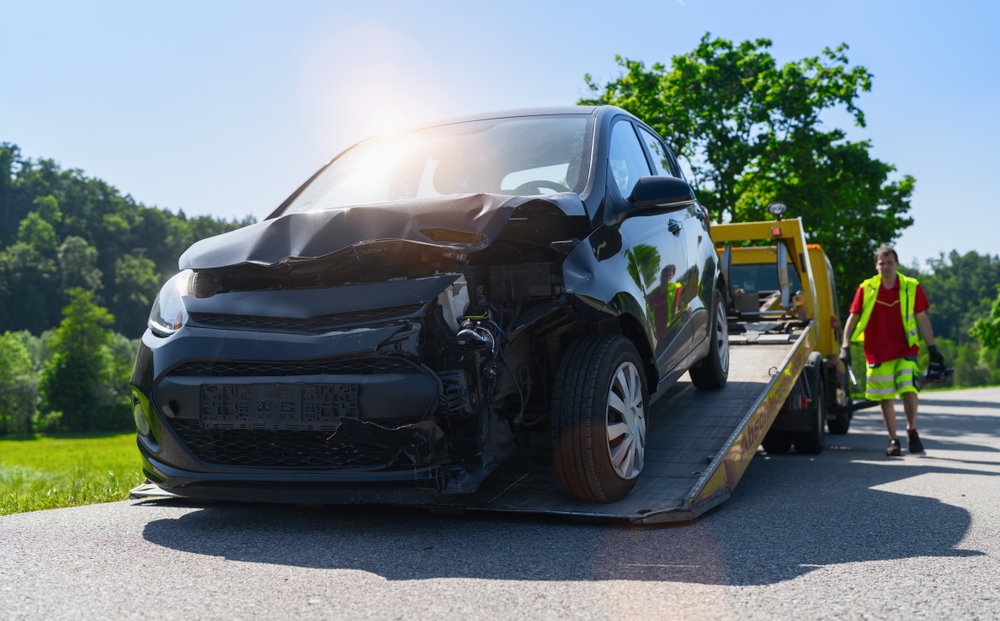 A crashed car is being towed by a professional junk car removal service in Lemont, IL.