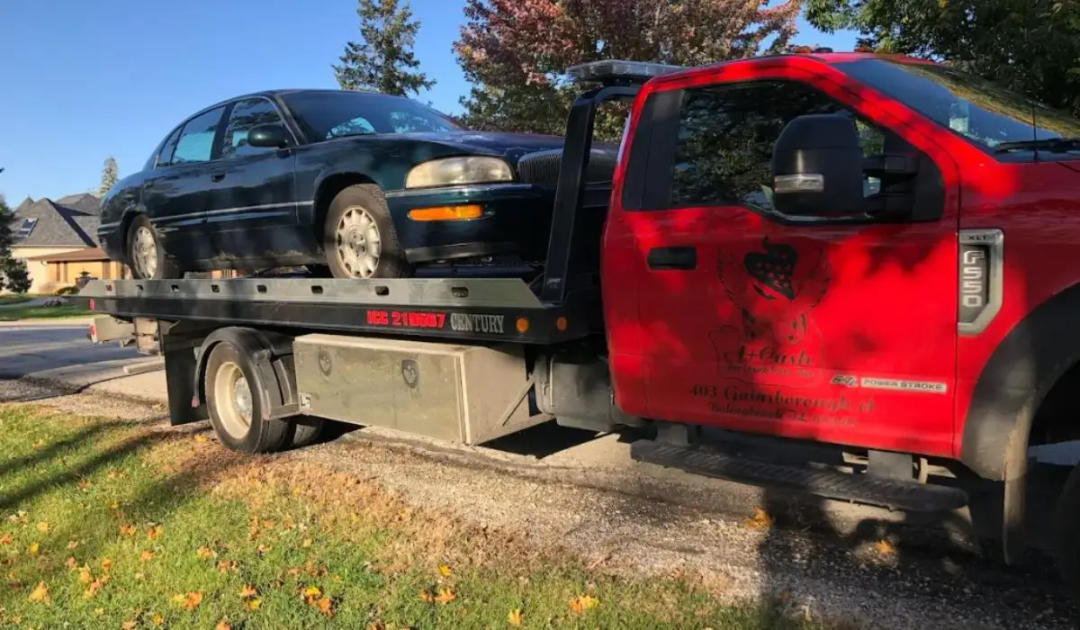 Tow truck hauls away old sedan during junk car selling process in Joliet, IL residential neighborhood.