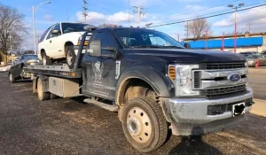 Tow truck from A+ Cash For Junk Cars hauling a flood-damaged car in Joliet IL, highlighting local pickup service for damaged vehicles.